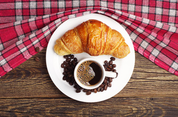 Tasty croissant and cup of coffee