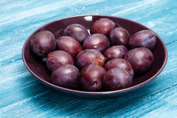 Fresh tasty plums in a bowl
