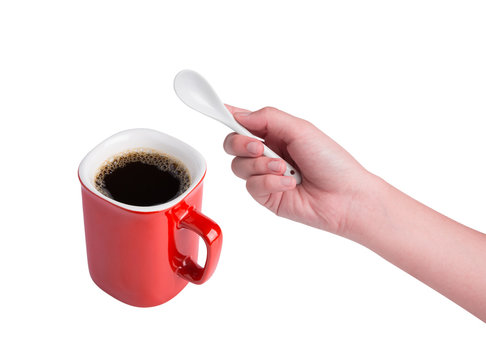 Hand Holding White Spoon And Red Cup Of Coffee Isolated On White