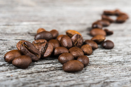 close up of coffee beans  on wooden background.