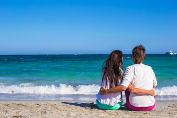 Fototapeta premium Back view of romantic couple at white beach during tropical