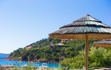 Wooden deck chairs and umbrellas near infinity pool in luxury