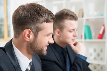 Close-up portrait of two handsome businessmen in suits