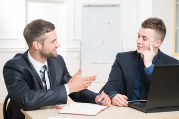 Waist-up portrait of two handsome businessmen in suits