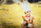 cute boy dressed as a bunny with fresh carrots in hands