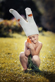cute boy dressed as a bunny with fresh carrots in hands