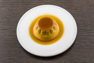Creme caramel vanilla custard dessert or flan on white dish