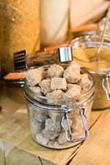Cane sugar in a jar on wooden table
