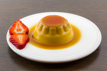 Creme caramel vanilla custard dessert or flan on white dish with
