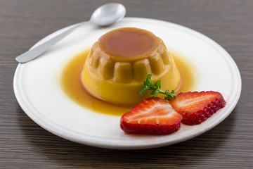 Creme caramel vanilla custard dessert or flan on white dish with