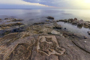 cat painted on the stone and the bright sky at sunset
