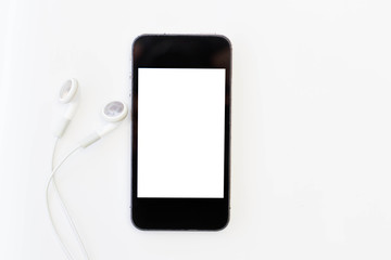 Closeup of black smartphone with white screen with headphones.