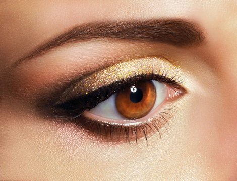 Mascara. Close Up Woman's Eye with Golden Eyeshadow