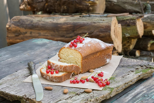 Fruit cake with red currant and almond on a garden table