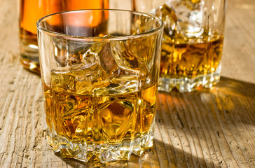 Zwei Tumbler mit Whisky und Flasche