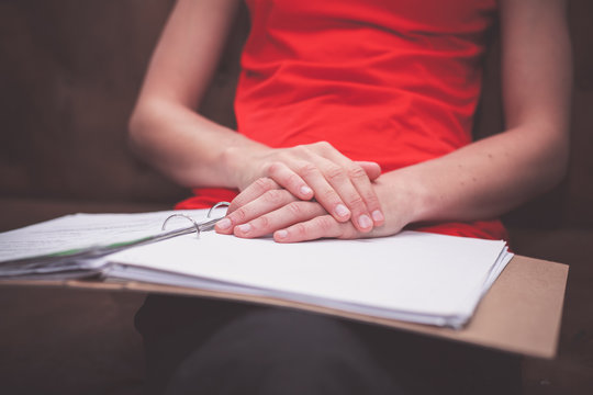 Woman sitting on sofa with documents