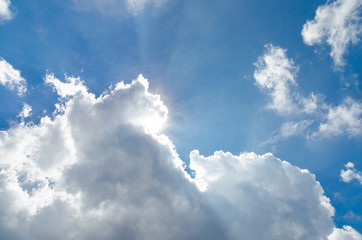 Sun behind cloud and blue sky