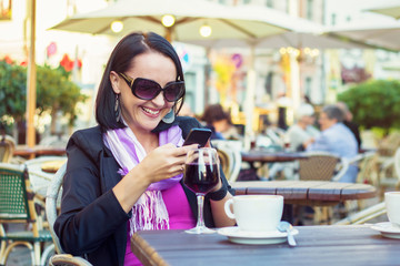 Attractive young woman using mobile phone while sitting in cafe