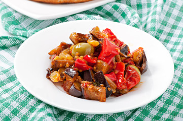 caponata with raisins and pine nuts decorated with a leaf of bas