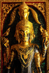 Fototapeta na wymiar High contrast image of golden buddha sculptures on the temple en