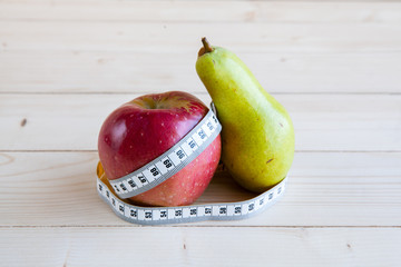 pear and apple  on the wooden background, shape of the body