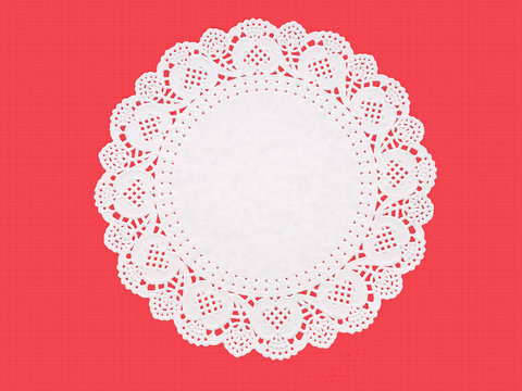 Fancy paper doily, round, perforated, embossed, on textured red.