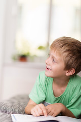 Fototapeta premium junge liest ein buch auf dem sofa