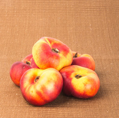 flat peaches (donut peaches) on a background