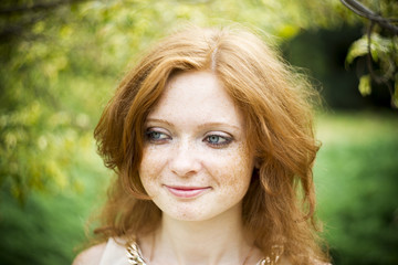 Naklejka premium Portrait of redhead girl with blue eyes on nature