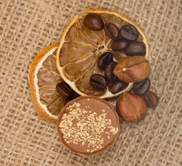 Fototapeta na wymiar Sweet, lemon, nuts and coffee beans on burlap