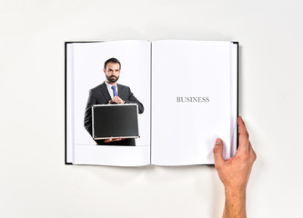 Young businessman with his briefcase printed on book