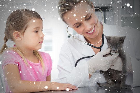 Composite image of female veterinarian examining kitten