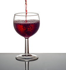 Red wine pouring into glass.