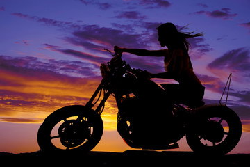 Fototapeta na wymiar silhouette of a woman on a motorcycle wind blowing