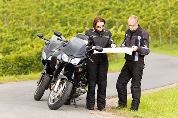 Zwei Motorradfahrer blicken auf die Strassenkarte
