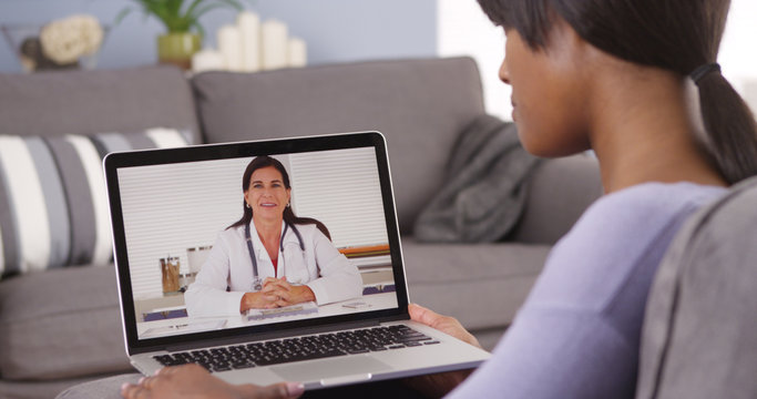 Black Woman Video Chatting With Doctor On Laptop