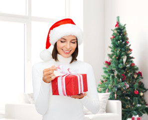 smiling woman in santa helper hat with gift box