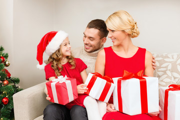 smiling family holding many gift boxes
