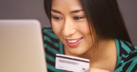 Close up of Japanese woman typing in credit card information