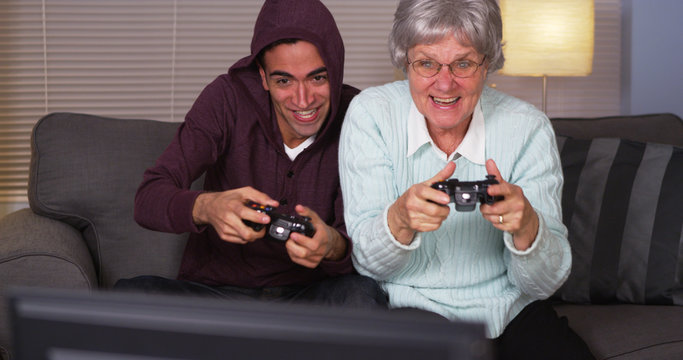 Hispanic grandson and grandmother playing video games