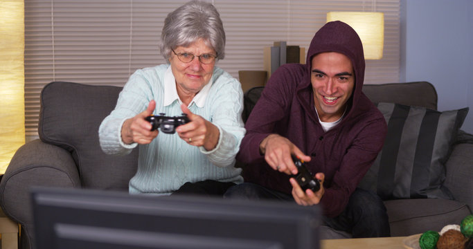 Elderly woman playing videogames with Hispanic man