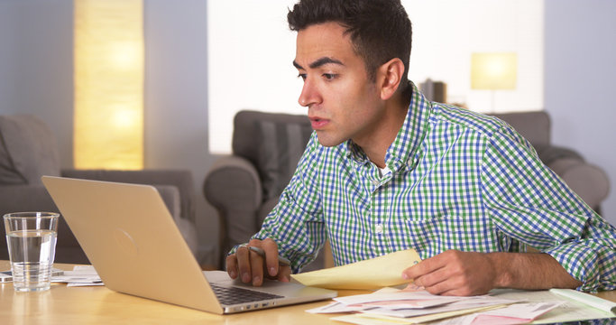 Hispanic Man Paying Bills At Home