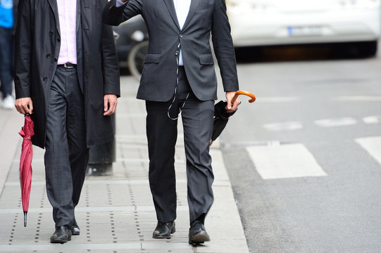 Anynomus men walking talking on sidewalk