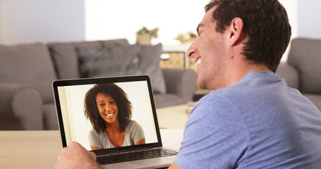 Multi-ethnic friends webcamming on laptop