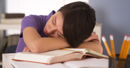 Asian woman sleeping on top of books