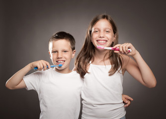 children brushing her teeth on a gray background