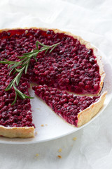 Tart with red bilberry on a white plate