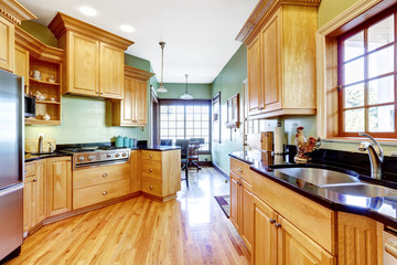 Light tones kitchen cabinets with black counter top
