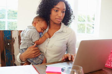 Mother With Baby Working In Office At Home - Powered by Adobe