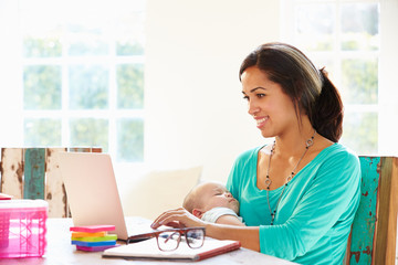 Mother With Baby Working In Office At Home